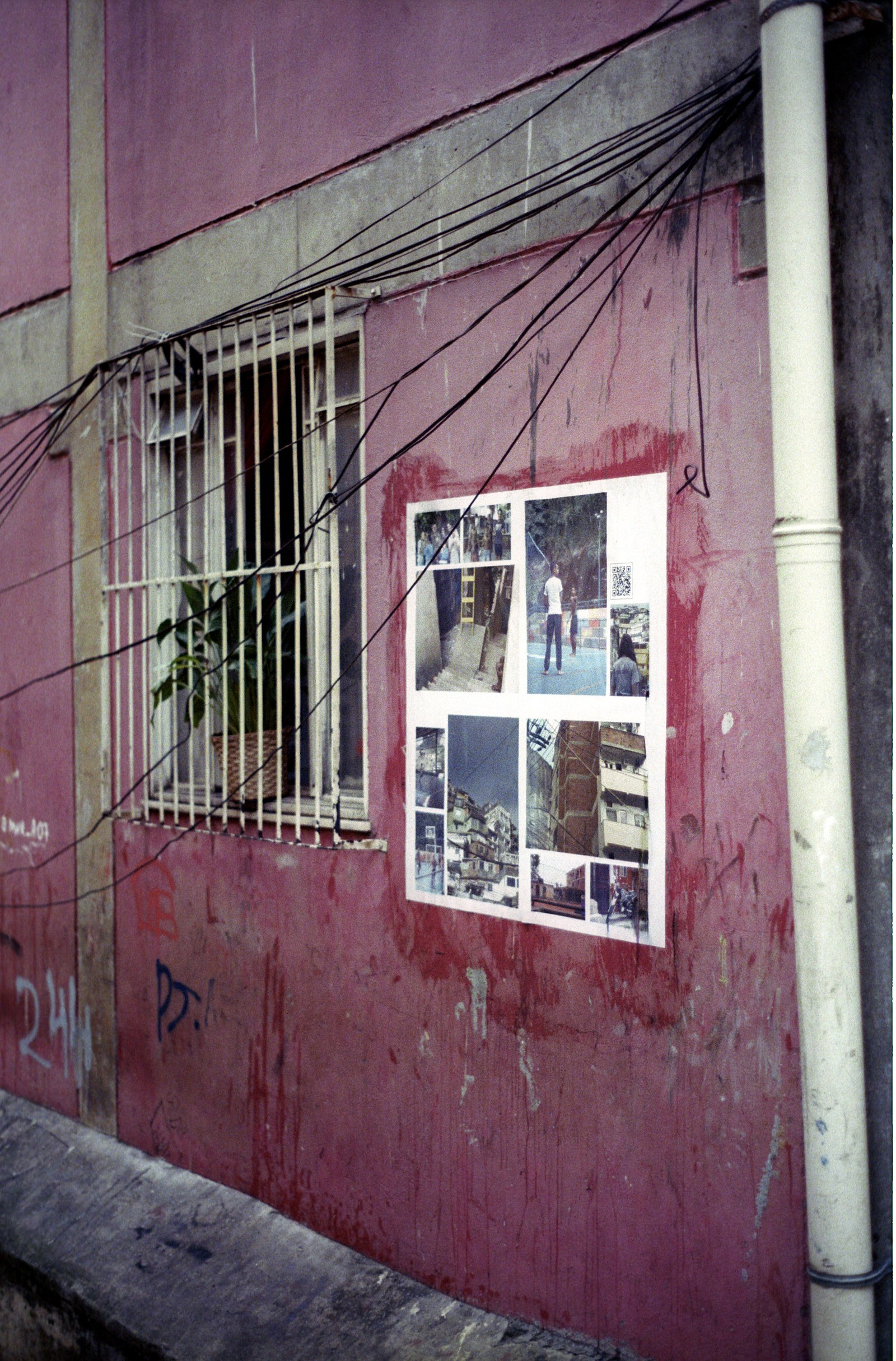 um cartaz num muro rosa, num beco