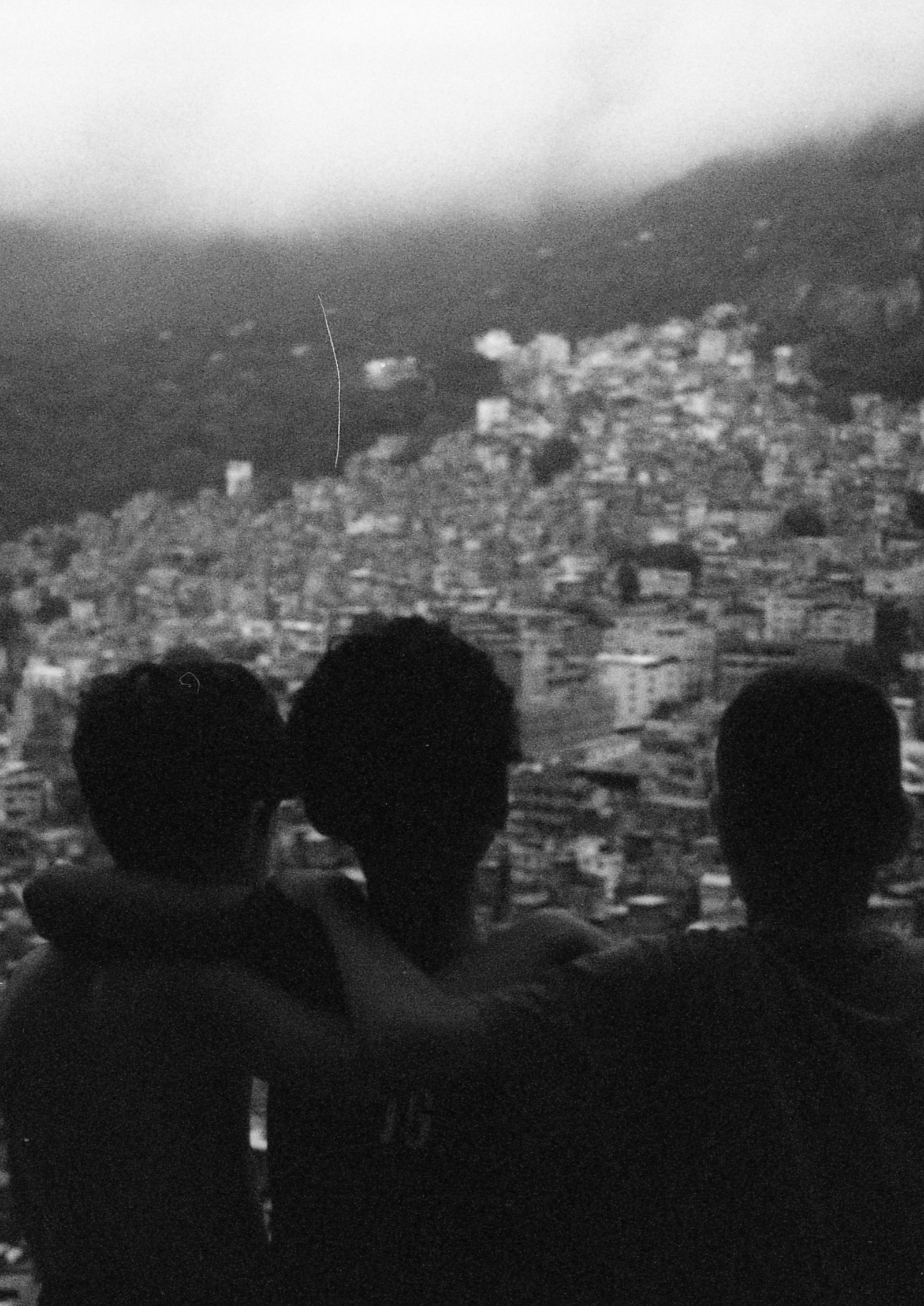 tres niños de espaldas miran la favela, en blanco y negro