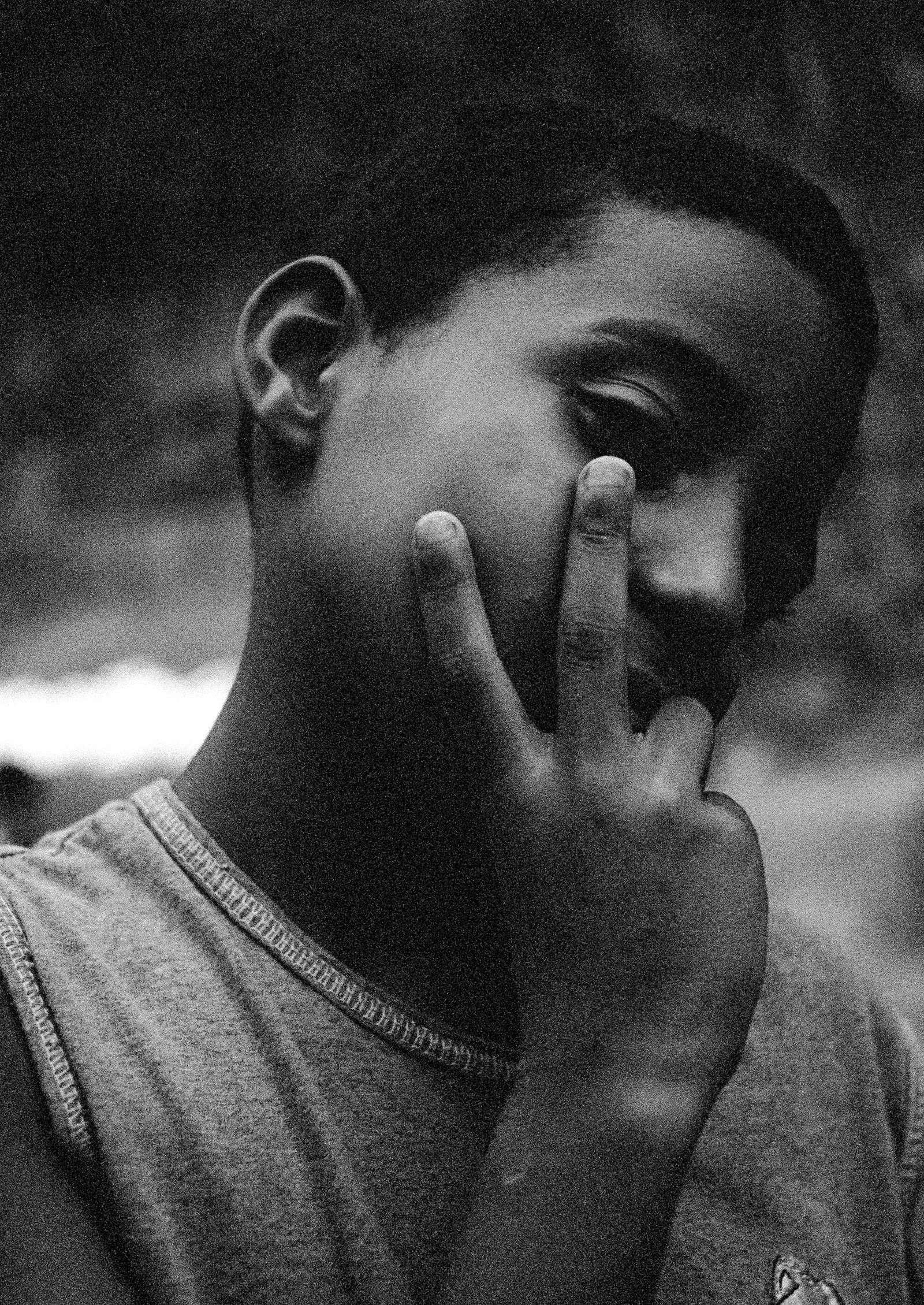 retrato en blanco y negro de un chico, con dos dedos en la mejilla