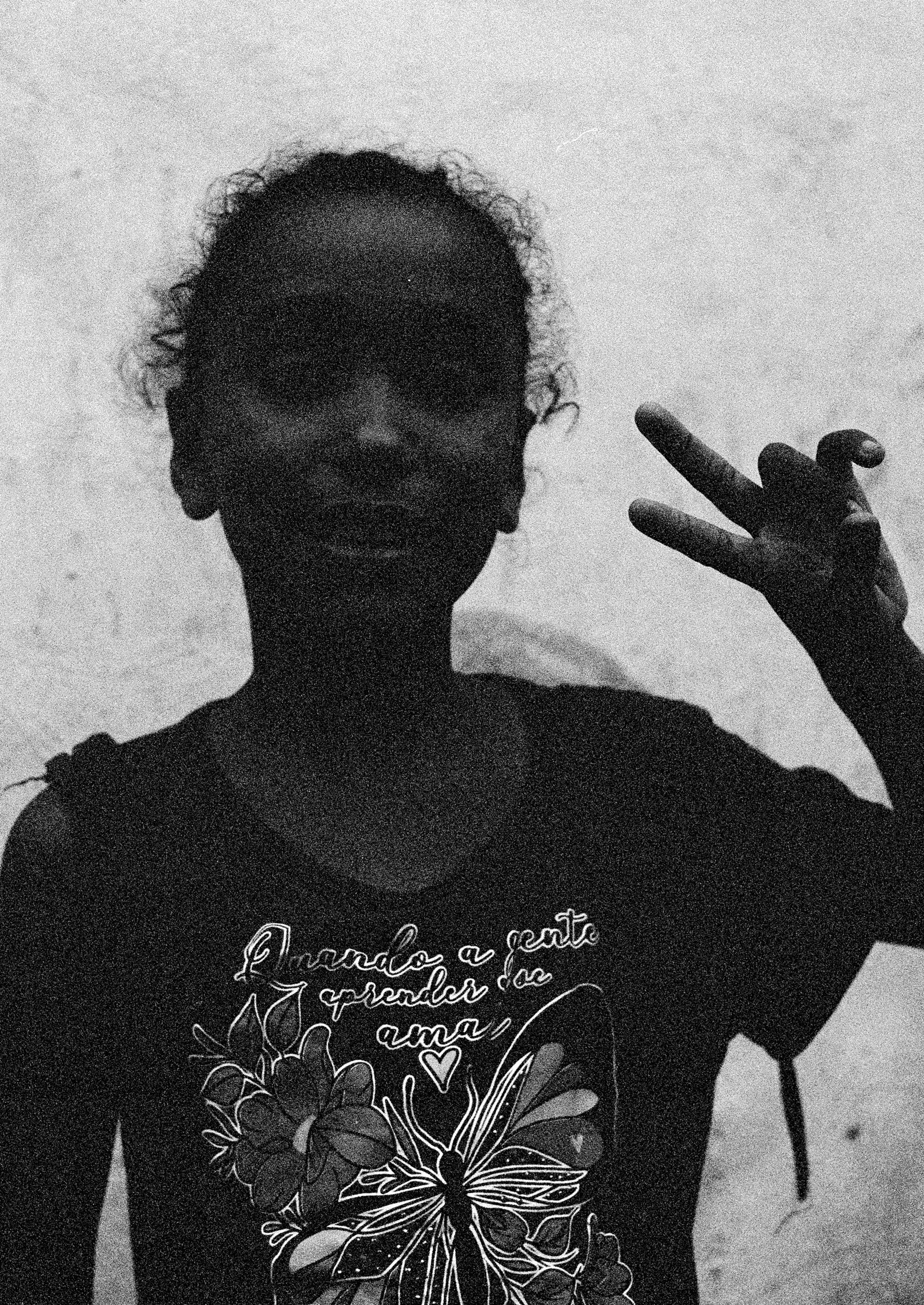 una niña saluda con la mano, en blanco y negro